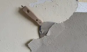 Spachtel schält Tapete ab. Die Arbeit, Tapete entfernen, ist im Gange.