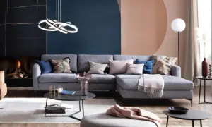 Stilvolle Ideen für ein graues Sofa: Kissen in Rosa, Blau und mit Blattmuster, eine Decke und ein Beistelltisch schaffen Gemütlichkeit.