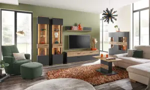 Modernes **interior wohnzimmer** mit bequemer Couch, grünem Sessel, Vitrinen und TV-Möbel. Ein bunter Teppich und ein auffälliger Kronleuchter runden das Bild ab.