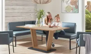 Gemütliches kleines Esszimmer einrichten mit Eckbank und Holztisch. Mutter und Kind spielen am Tisch.