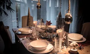 Festliche weihnachtstisch dekoration mit Kerzen, Tannenbäumen und Lichterketten.