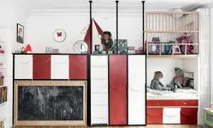 Kreative geschwisterzimmer ideen: Kinder spielen in einem bunten Zimmer mit Hochbetten, Rutsche und Tafel.