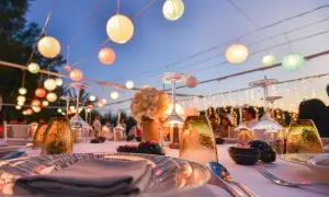 Festlich gedeckte Tafel mit bunten Lampions als Dekoideen Hochzeit im Garten. Gläser, Blumen und Lichterketten schaffen romantische Stimmung.