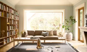 Gemütliche Anordnung Sofa Wohnzimmer mit Bücherregal, Kamin und großem Fenster.