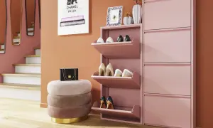 Stilvoller Eingangsbereich mit rosa Schuhschränken, Hocker und Wandspiegeln.