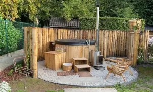 Natürliche Whirlpool Garten Ideen: Ein Holz-Whirlpool mit Holzverkleidung und Ofen, umgeben von rustikalen Holzstämmen.