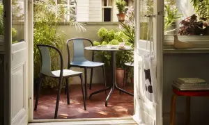 Gemütliche Balkon Ideen: Ein Tisch mit zwei Stühlen lädt zum Verweilen ein, umgeben von üppigem Grün.