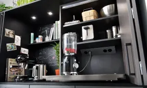 Schwarzer Küchenschrank mit integrierter Steckdose, Mixer, Kaffeemaschine und Toaster.