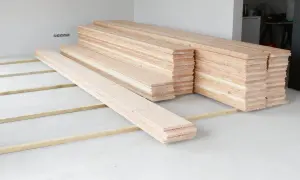 Holzdielen liegen bereit, um den **Boden auszugleichen**. Mehrere Stapel warten auf ihren Einsatz.