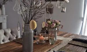 Tischdeko Ideen Alltag: Zweige, Schmetterlinge und Kerzenlicht schaffen eine gemütliche Atmosphäre auf dem Holztisch.