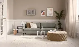 Kleines Wohnzimmer vorher-nachher: Gemütliche Couch, beiger Pouf, Teppich und Deko.