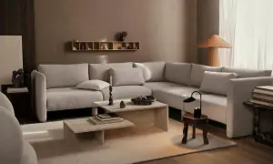 Beige Sofa, Holztöne und erdige Wände zeigen, welche Farben passen zusammen. Ein heller Teppich und dezente Deko schaffen Gemütlichkeit.