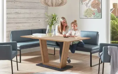 Gemütliches kleines Esszimmer einrichten mit Eckbank und Holztisch. Mutter und Kind spielen am Tisch.