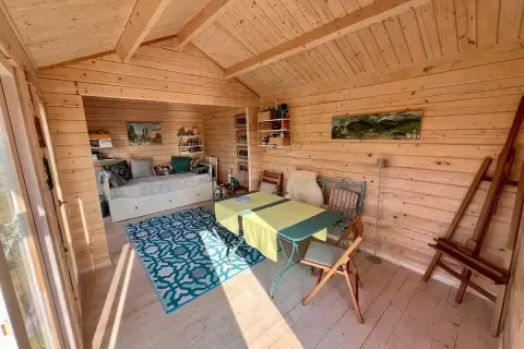 Gemütliches kleines Gartenhaus innen gestalten: Tagesbett, Esstisch und Staffelei laden zum Entspannen und Kreativsein ein.