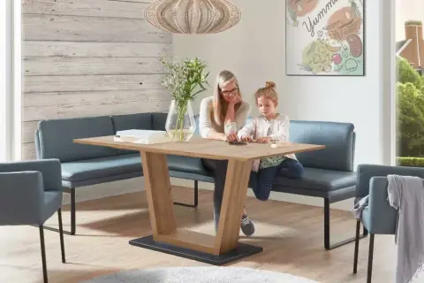 Gemütliches kleines Esszimmer einrichten mit Eckbank und Holztisch. Mutter und Kind spielen am Tisch.