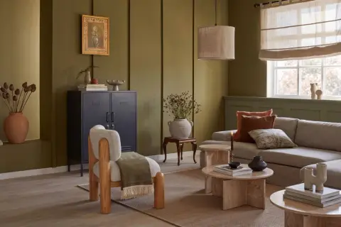 Gemütliches Wohnzimmer mit erdigen Tönen. Tolle wohnzimmer ideen farbe: Olivgrün an den Wänden, kombiniert mit natürlichen Materialien und warmen Akzenten.