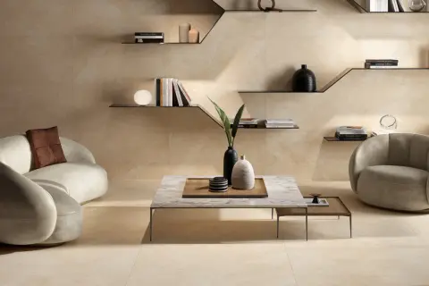 Ein Wohnzimmer in warmen, erdigen Tönen. Die Wandfliesen und der Boden haben die Farbe Ecru, ein sanfter, cremiger Beigeton.