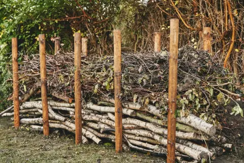 Holzstapel und Äste bilden eine rustikale totholzhecke anlegen. Ein natürlicher Lebensraum für Tiere entsteht.