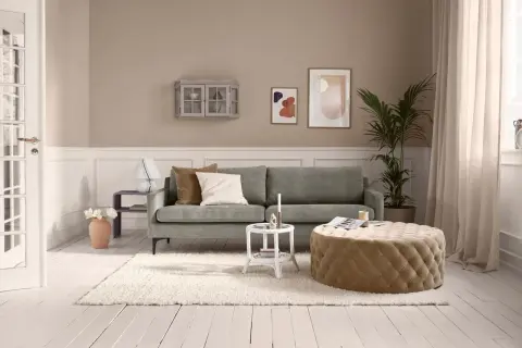 Kleines Wohnzimmer vorher-nachher: Gemütliche Couch, beiger Pouf, Teppich und Deko.