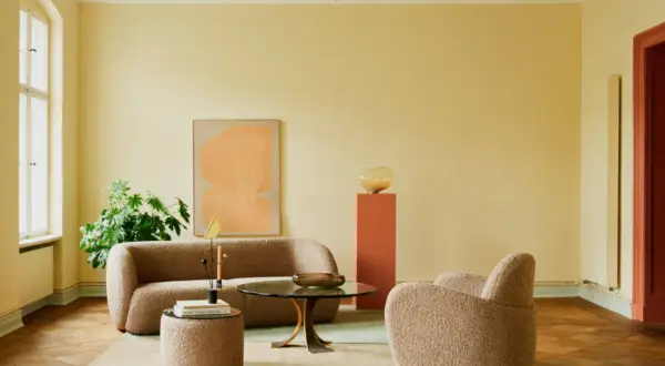 Ein Wohnzimmer mit gelben Wänden und einer grünen Decke. Die **Decke und Wand gleiche Farbe** ist hier nicht gegeben, aber die Farben harmonieren.