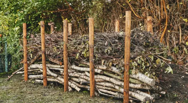 Holzstapel und Äste bilden eine rustikale totholzhecke anlegen. Ein natürlicher Lebensraum für Tiere entsteht.