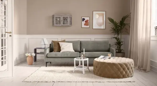 Kleines Wohnzimmer vorher-nachher: Gemütliche Couch, beiger Pouf, Teppich und Deko.