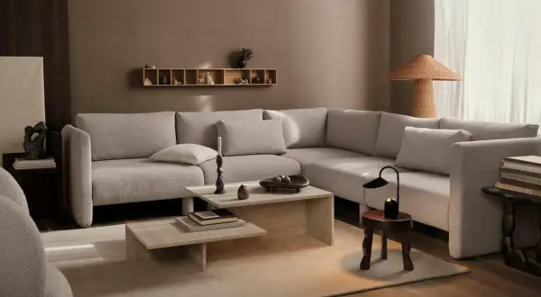 Beige Sofa, Holztöne und erdige Wände zeigen, welche Farben passen zusammen. Ein heller Teppich und dezente Deko schaffen Gemütlichkeit.