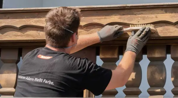 Mann bürstet Holzpaneele für das Streichen.
