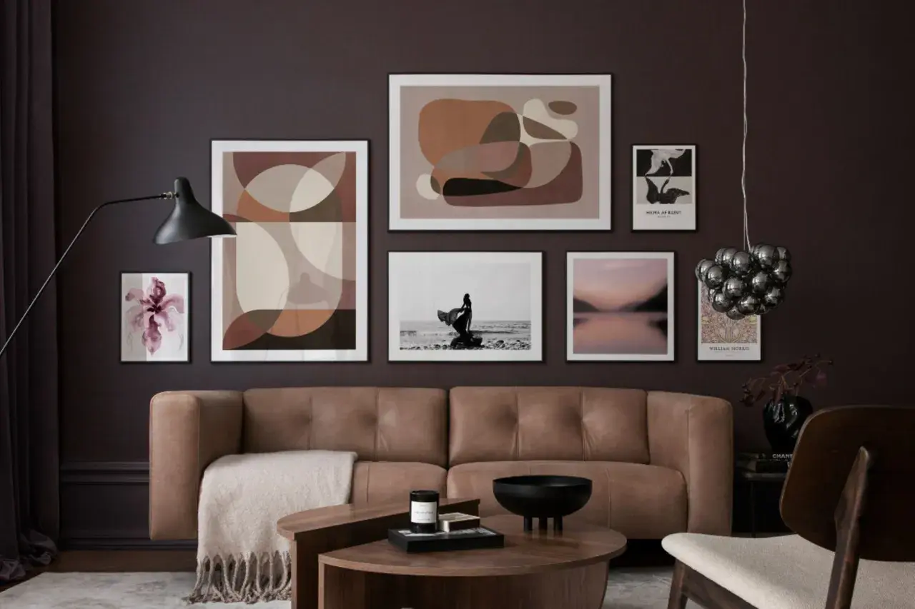 Ein braunes Ledersofa vor einer Wand mit abstrakter Kunst und einem Foto. Welche Farbe passt zu Schwarz? Hier: Braun und Beige.