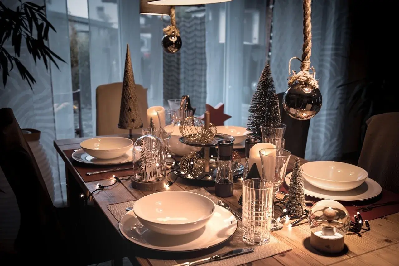 Festliche weihnachtstisch dekoration mit Kerzen, Tannenbäumen und Lichterketten.