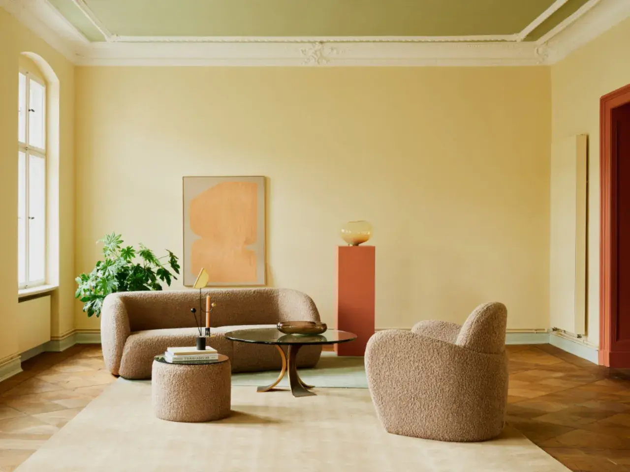 Ein Wohnzimmer mit gelben Wänden und einer grünen Decke. Die **Decke und Wand gleiche Farbe** ist hier nicht gegeben, aber die Farben harmonieren.