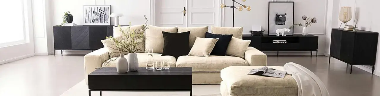 Ein helles Wohnzimmer mit einem beigen Sofa, schwarzen Akzenten und Dekorationen. Hier siehst du, was sind neutrale farben: Beige, Schwarz und Weiß dominieren.