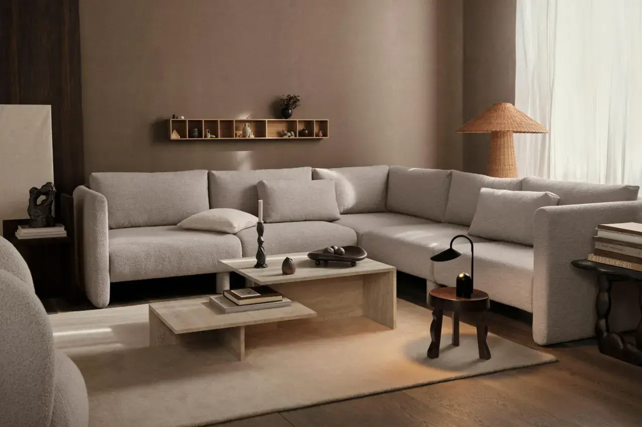 Beige Sofa, Holztöne und erdige Wände zeigen, welche Farben passen zusammen. Ein heller Teppich und dezente Deko schaffen Gemütlichkeit.