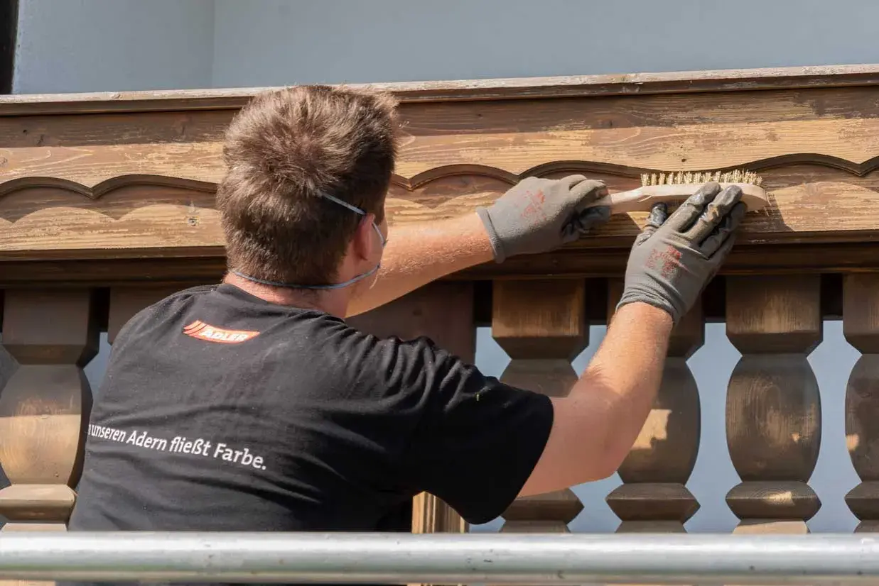 Mann bürstet Holzpaneele für das Streichen.
