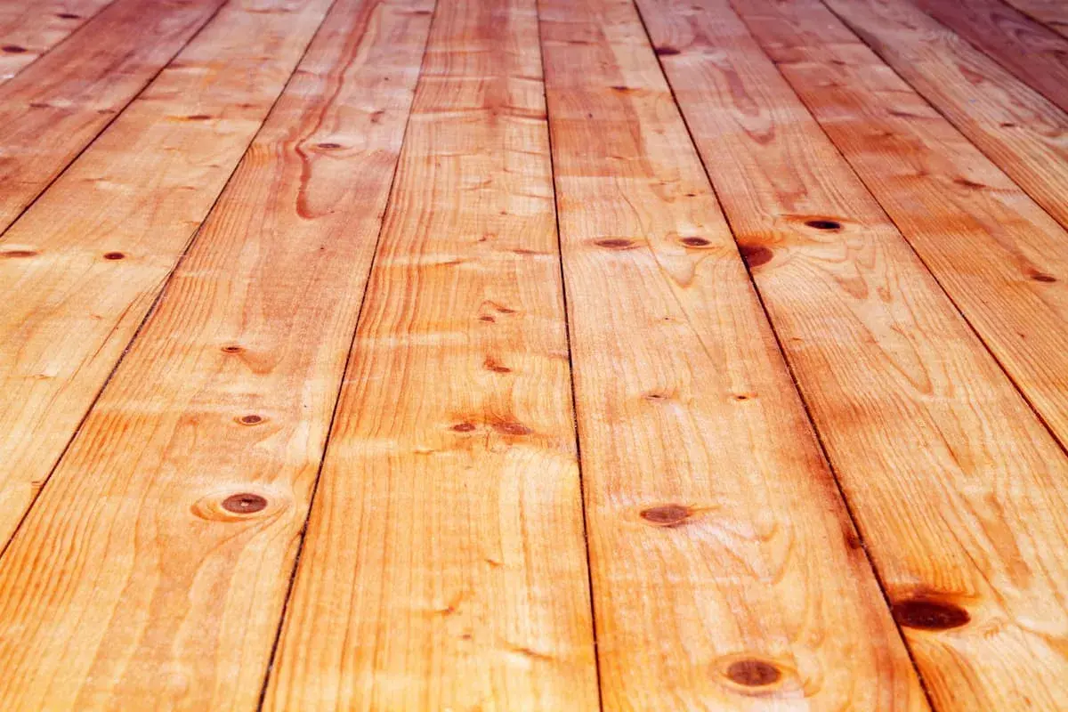 Holzbretter für den Dielenboden verlegen. Natürliche Holzmaserung und Astlöcher.