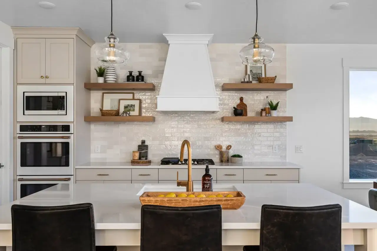 Moderne Küche mit goldenem Wasserhahn. Welche Farbe passt zu Gold? Hier: helle Fliesen, Holz und cremefarbene Schränke.
