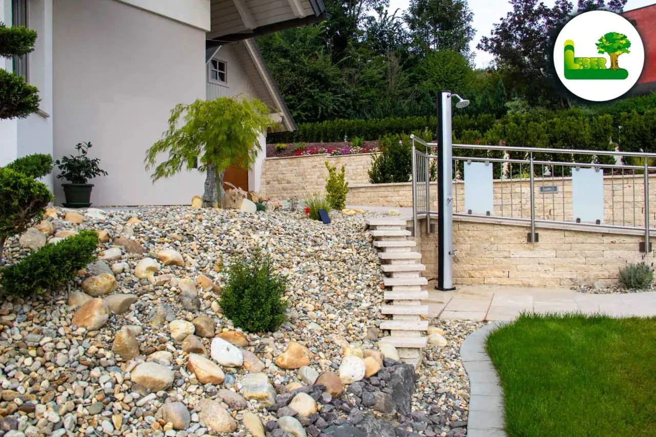 Ein moderner Vorgarten gestalten: Kiesflächen, Steintreppen und eine Außendusche schaffen ein stilvolles Ambiente.