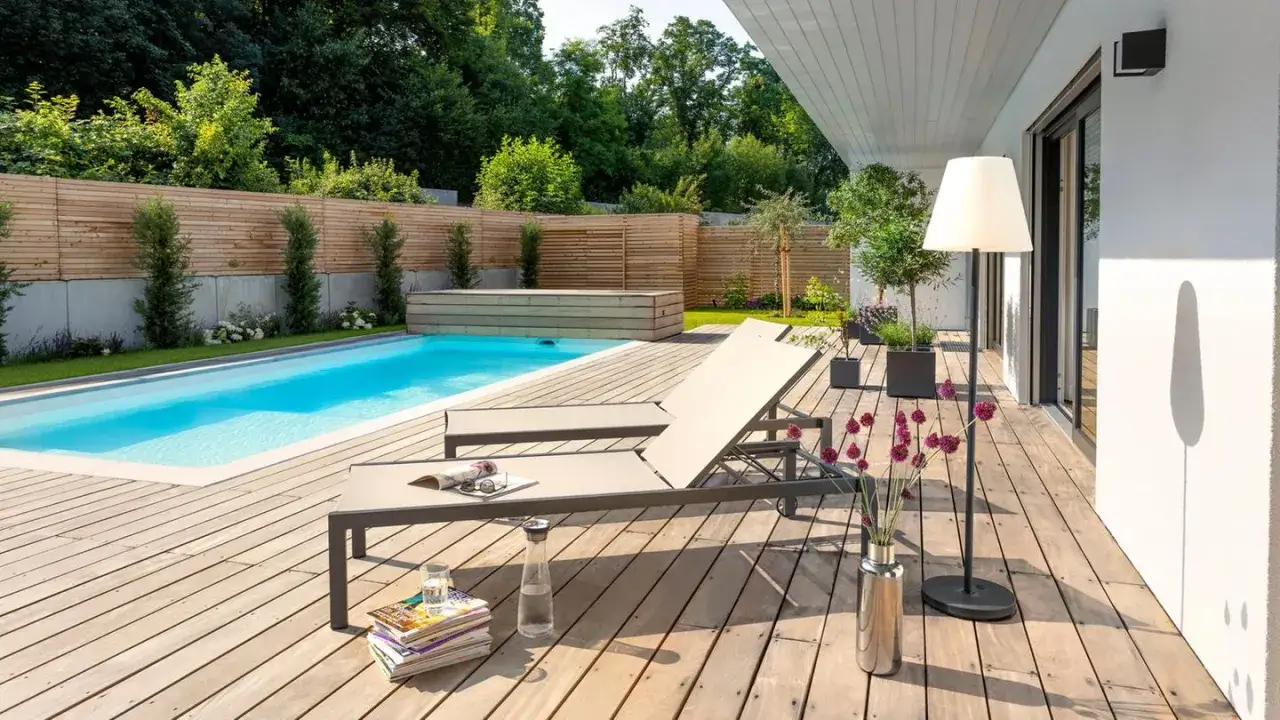 Traumhafter Garten mit pool selbst bauen-Ideen: Einladende Liegen am blauen Pool, Holzdeck und &uuml;ppige gr&uuml;ne Bepflanzung.