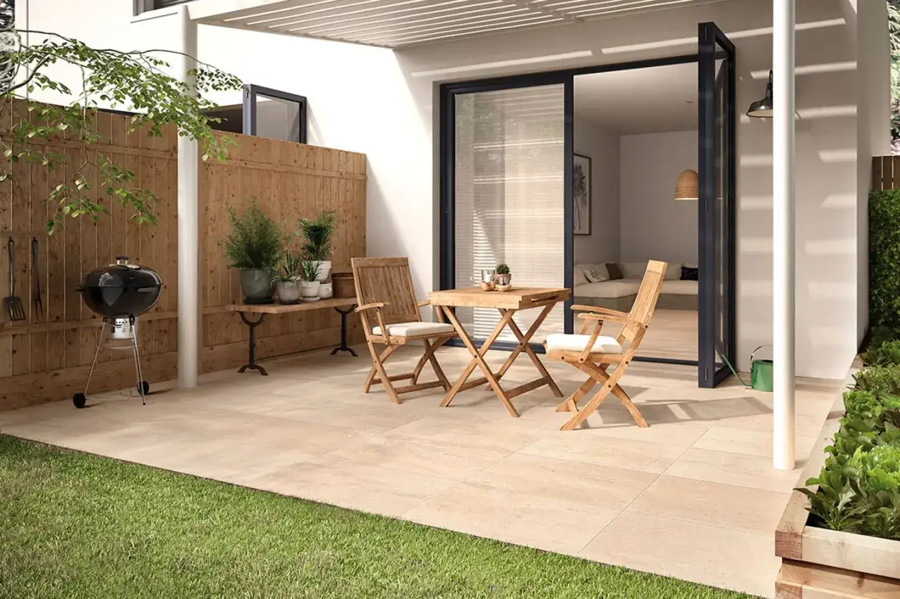 Ein moderner kleiner Garten am Reihenhaus mit Grill, Holztisch und St&uuml;hlen. Perfekt f&uuml;r entspannte Abende.