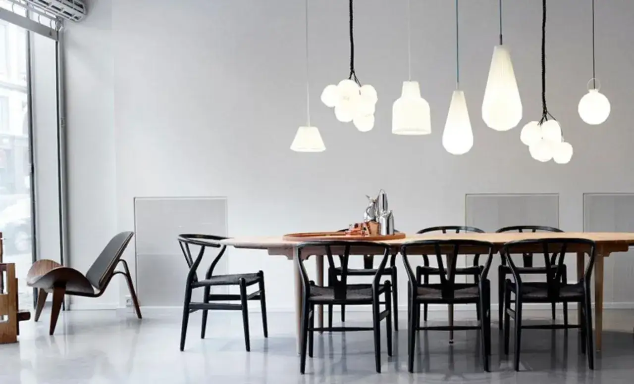 Moderne Esszimmer mit schwarzen Stühlen und einem Holztisch. Welche Farbe passt zu Schwarz? Hier: Weiß und helle Holztöne.