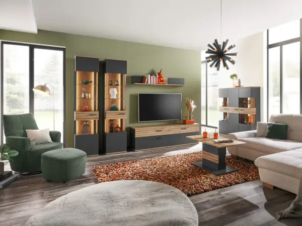 Modernes **interior wohnzimmer** mit bequemer Couch, grünem Sessel, Vitrinen und TV-Möbel. Ein bunter Teppich und ein auffälliger Kronleuchter runden das Bild ab.