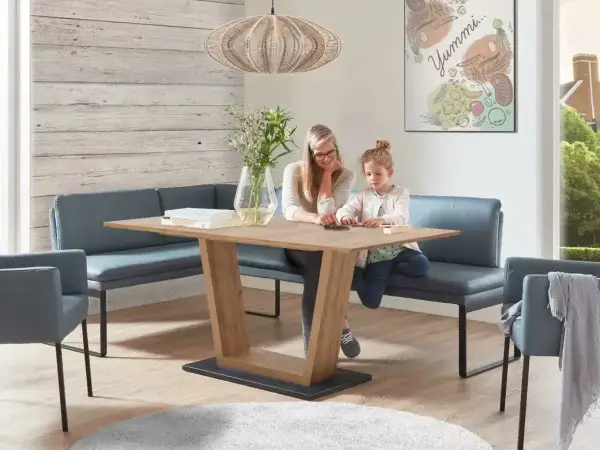 Gemütliches kleines Esszimmer einrichten mit Eckbank und Holztisch. Mutter und Kind spielen am Tisch.