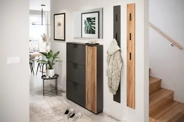Ein moderner, heller kleiner Flur mit Schuhschrank, Spiegel, Garderobe und Treppe.