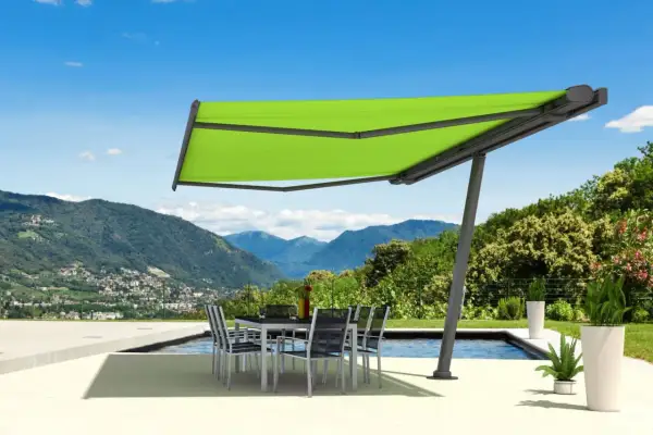 Moderne sonnensegel befestigen ideen: ein ausfahrbares Sonnensegel schützt eine Terrasse mit Esstisch und Stühlen vor der Sonne, mit Bergpanorama.