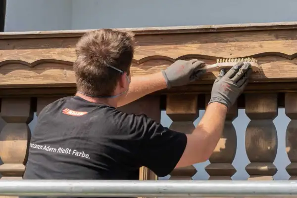 Mann bürstet Holzpaneele für das Streichen.